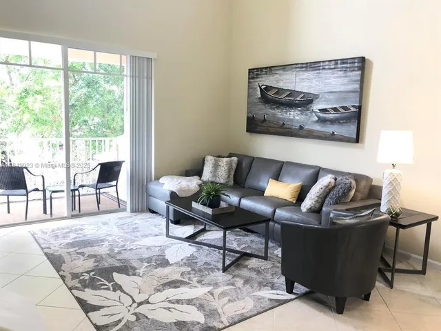 a living room with furniture a rug and a large window