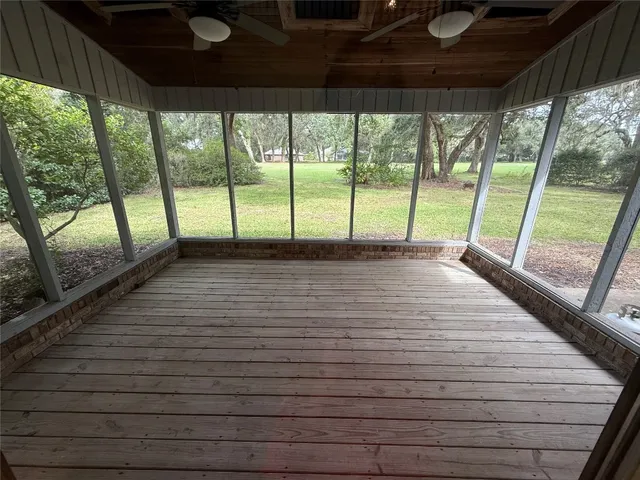 a view of empty room with wooden floor and floor to ceiling window