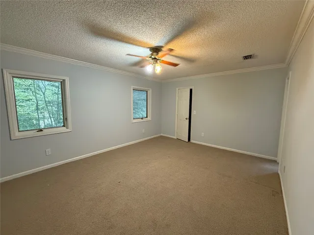 an empty room with a window and a fan