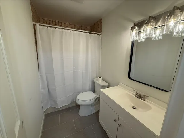 a bathroom with a sink and mirror with toilet