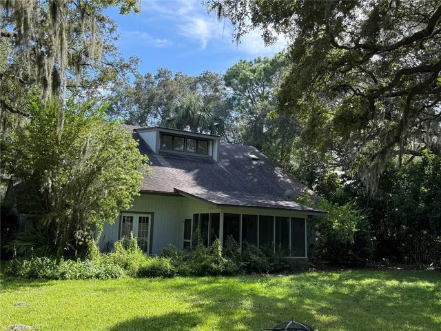a view of house with a yard and potted plants