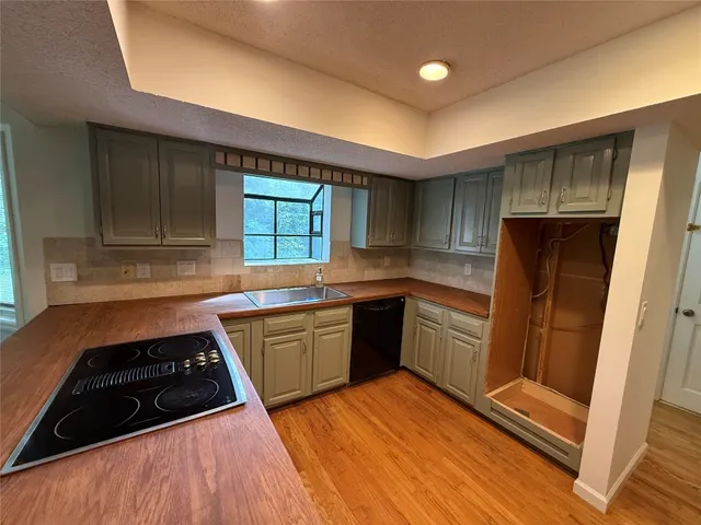 a kitchen with stainless steel appliances granite countertop a sink stove and cabinets