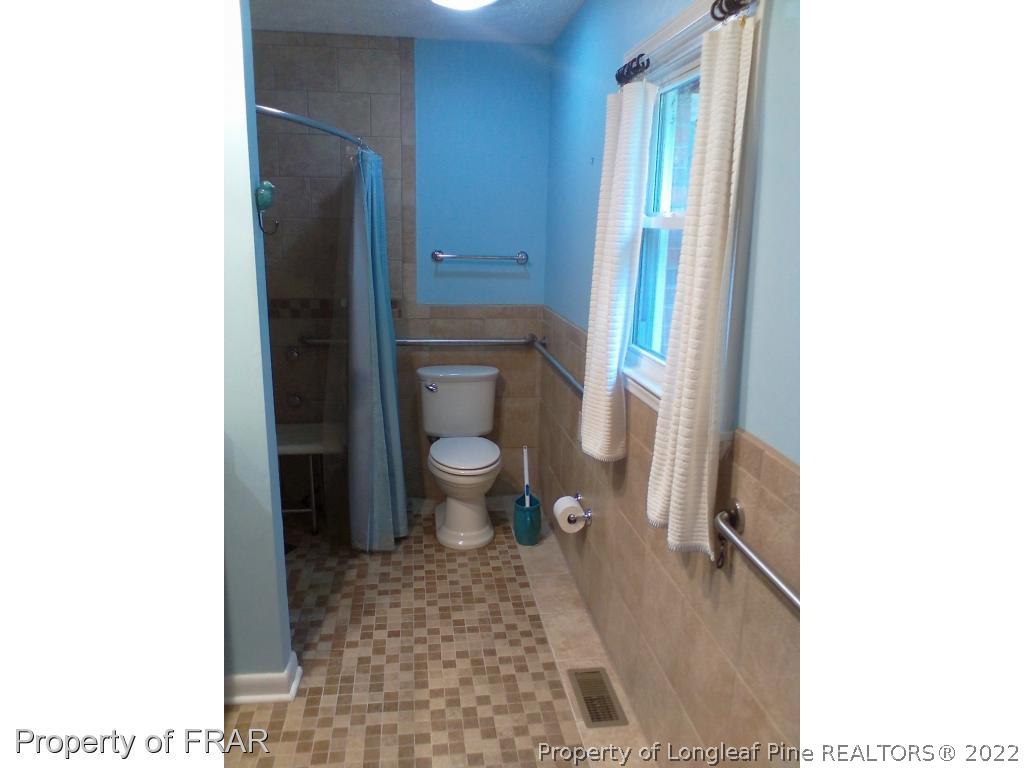 1305 Myra Road Rockfish, NC 28376 - Photo 15 of 17 a bathroom with a toilet and a shower