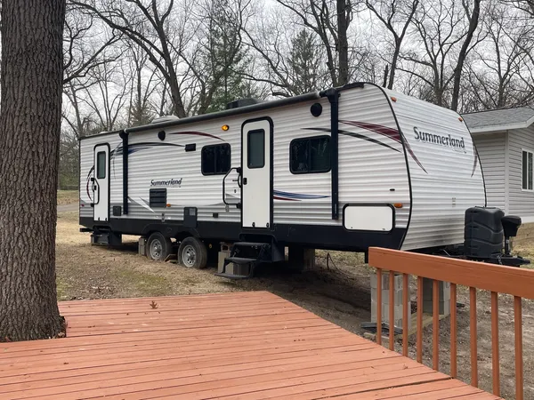 a view of a house with wooden deck and furniture