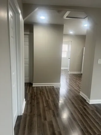 a view of hallway with stairs and wooden floor
