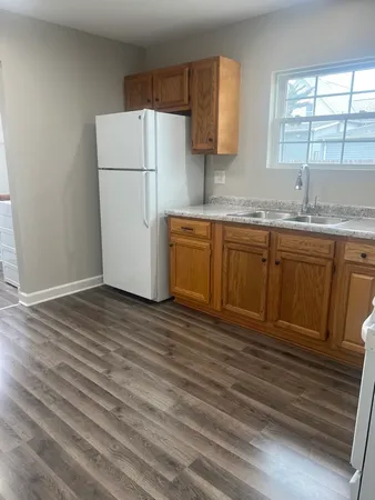 a kitchen with granite countertop a sink cabinets stainless steel appliances and a window