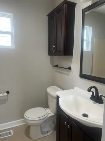 a bathroom with a sink a toilet and mirror