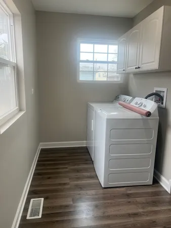 a storage room with wooden floor washer and dryer