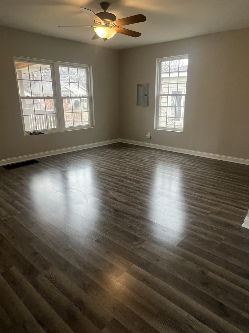 207 Davis Street Joliet, IL 60436 - Photo 4 of 23 an empty room with wooden floor and windows