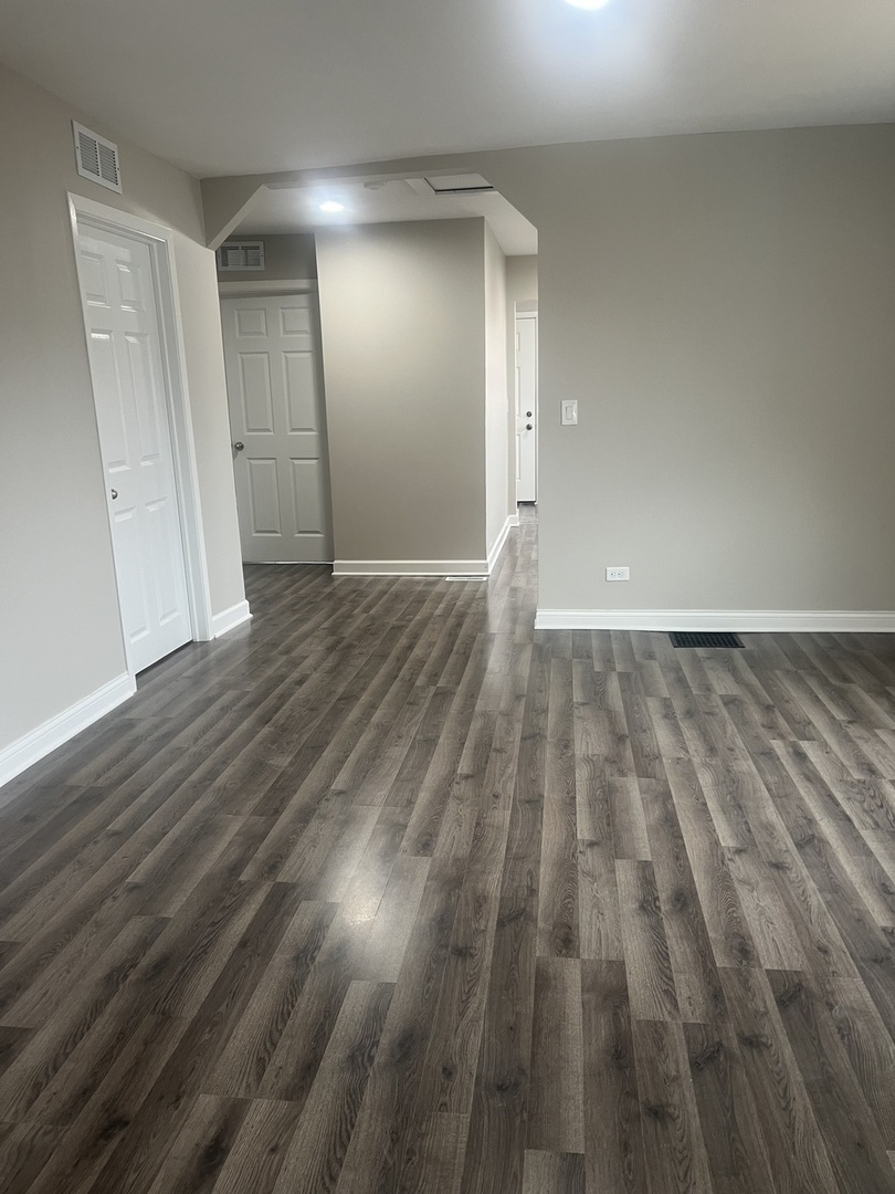 207 Davis Street Joliet, IL 60436 - Photo 8 of 23 wooden floor in an empty room