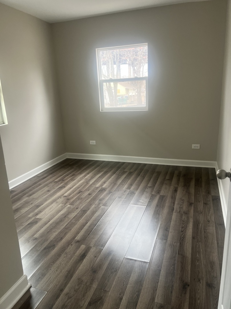 207 Davis Street Joliet, IL 60436 - Photo 9 of 23 an empty room with wooden floor and windows