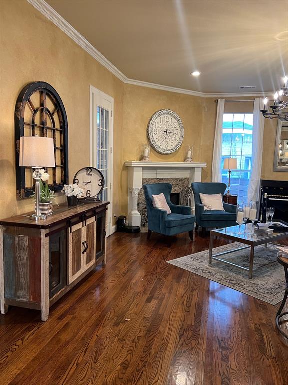 1625 Roma Lane Allen, TX 75013 - Photo 4 of 10 Hardwood flooring throughout featuring a decorative fireplace with a substantial mantel, crown molding, and recessed lighting