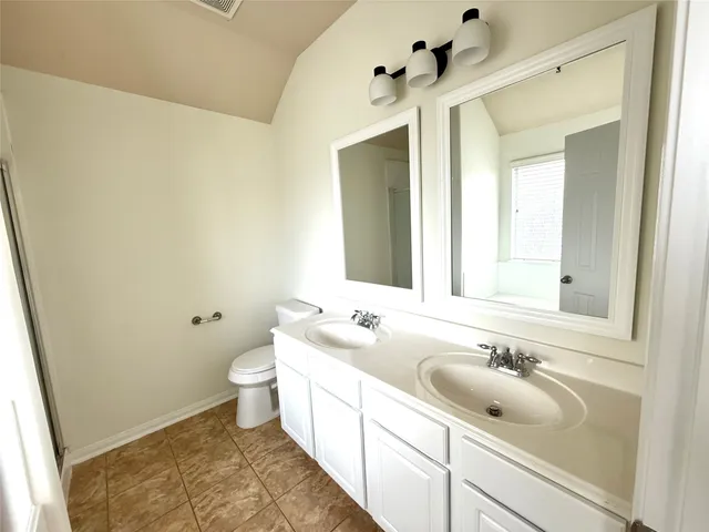 a bathroom with a sink and mirror with toilet