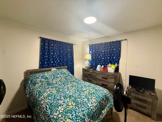 a bedroom with a bed and a television