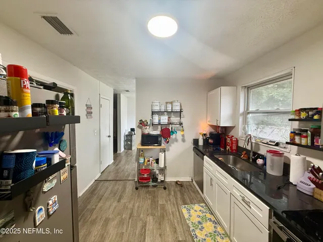 a kitchen that has a lot of cabinets a sink and a stove in it