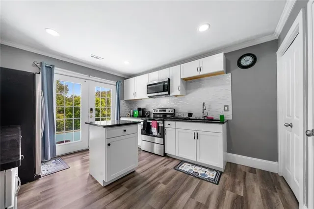 a kitchen with stainless steel appliances a stove top oven a sink dishwasher and a refrigerator