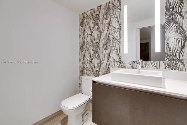 a bathroom with a sink a toilet and a mirror