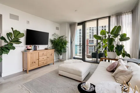 a bedroom with a large bed and a flat tv screen on dresser