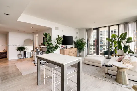 a living room with furniture a flat screen tv and a large window
