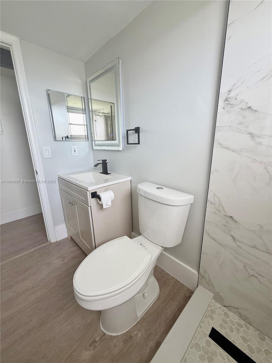 150 Southwest 134th Way, Unit 305R Pembroke Pines, FL 33027 - Photo 12 of 19 a white toilet sitting next to a bathroom sink and a mirror