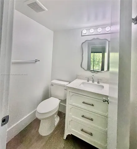 a bathroom with a sink a toilet and mirror