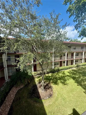 an empty room with windows and ceiling fan