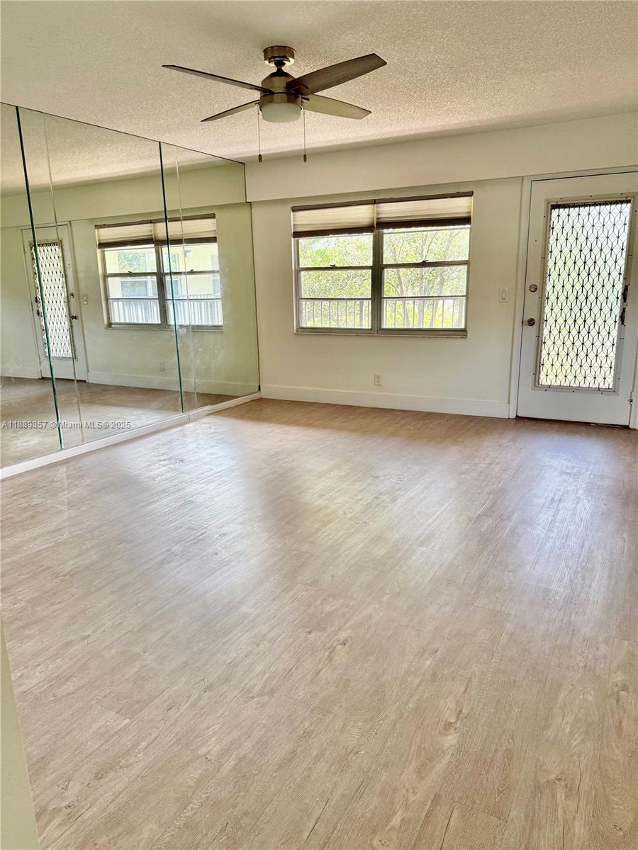 150 Southwest 134th Way, Unit 305R Pembroke Pines, FL 33027 - Photo 4 of 19 an empty room with wooden floor and windows