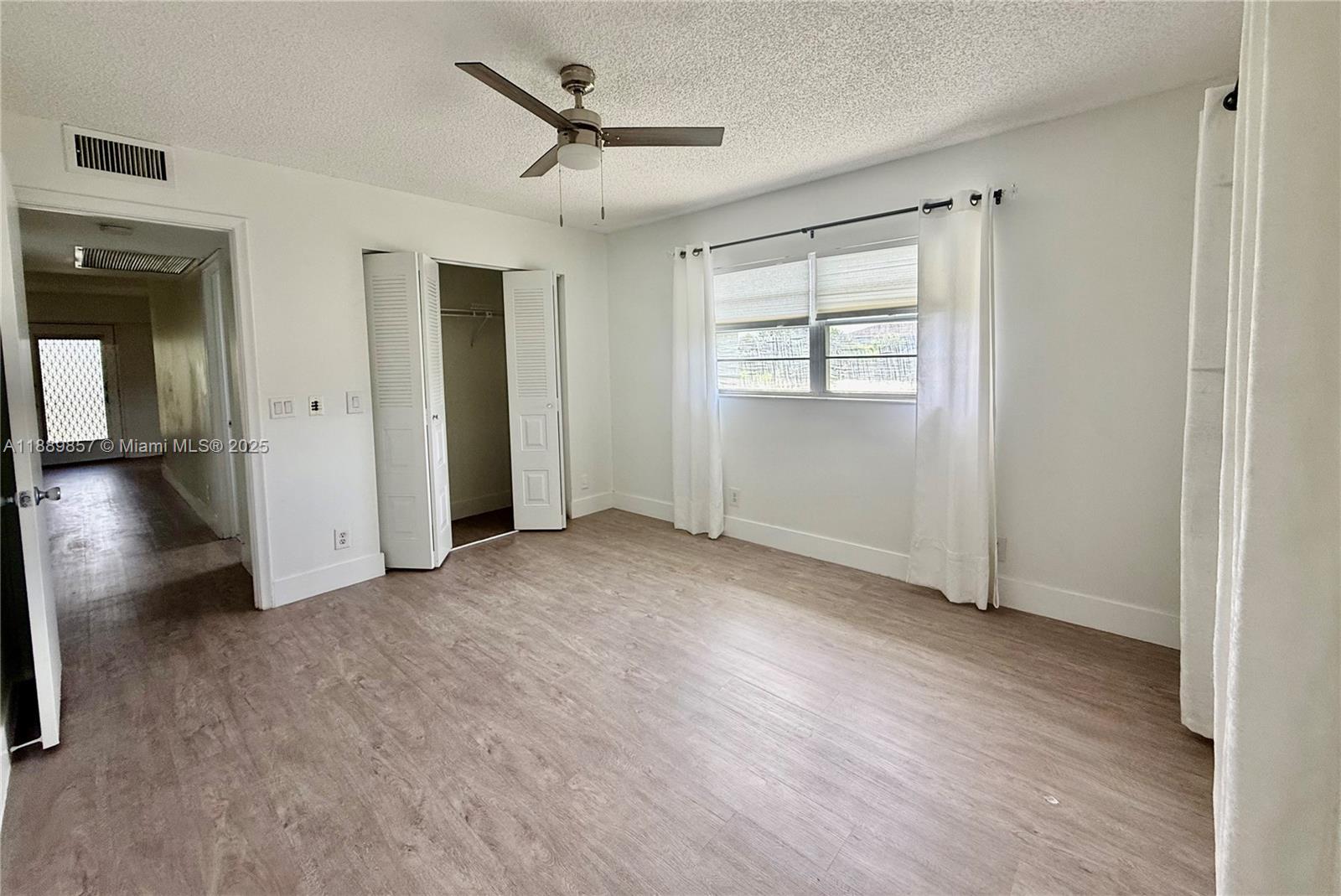150 Southwest 134th Way, Unit 305R Pembroke Pines, FL 33027 - Photo 7 of 19 a view of empty room with wooden floor and fan