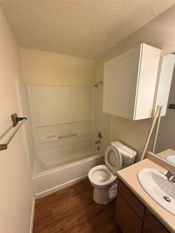 2504 Howellwood Way, Unit B Austin, TX 78748 - Photo 14 of 20 Full bath with dark wood-style flooring, vanity, shower / bath combination, and a textured ceiling