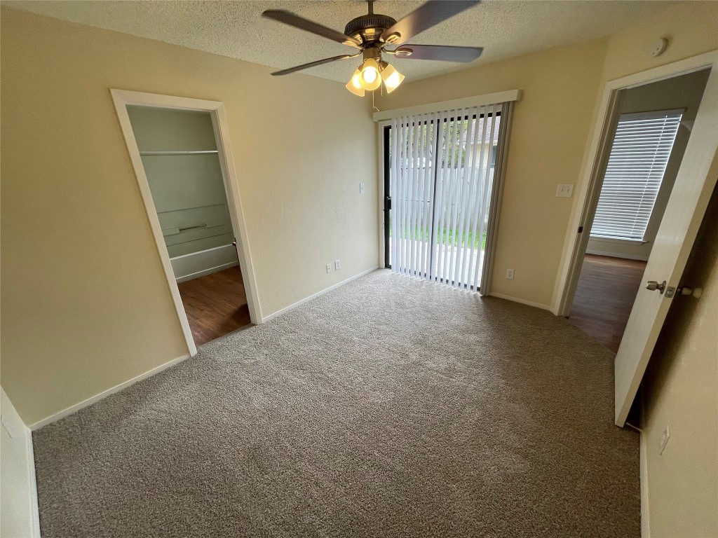 2504 Howellwood Way, Unit B Austin, TX 78748 - Photo 10 of 20 Unfurnished bedroom with a textured ceiling, carpet flooring, access to exterior, and a ceiling fan
