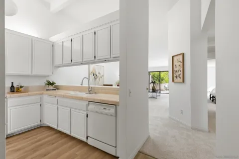 a kitchen with white cabinets and sink