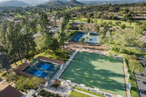 an aerial view of residential houses with outdoor space and trees