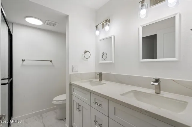 a bathroom with a sink a toilet and a mirror