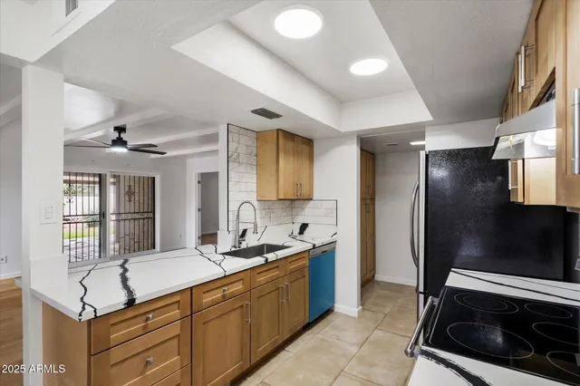 a kitchen with granite countertop a sink and stainless steel appliances