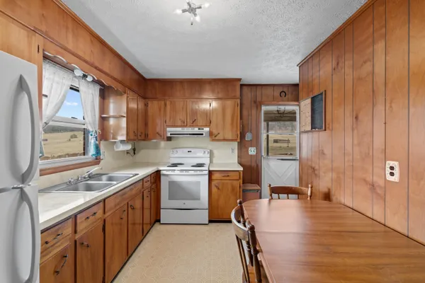 a kitchen with granite countertop a sink a stove and a microwave