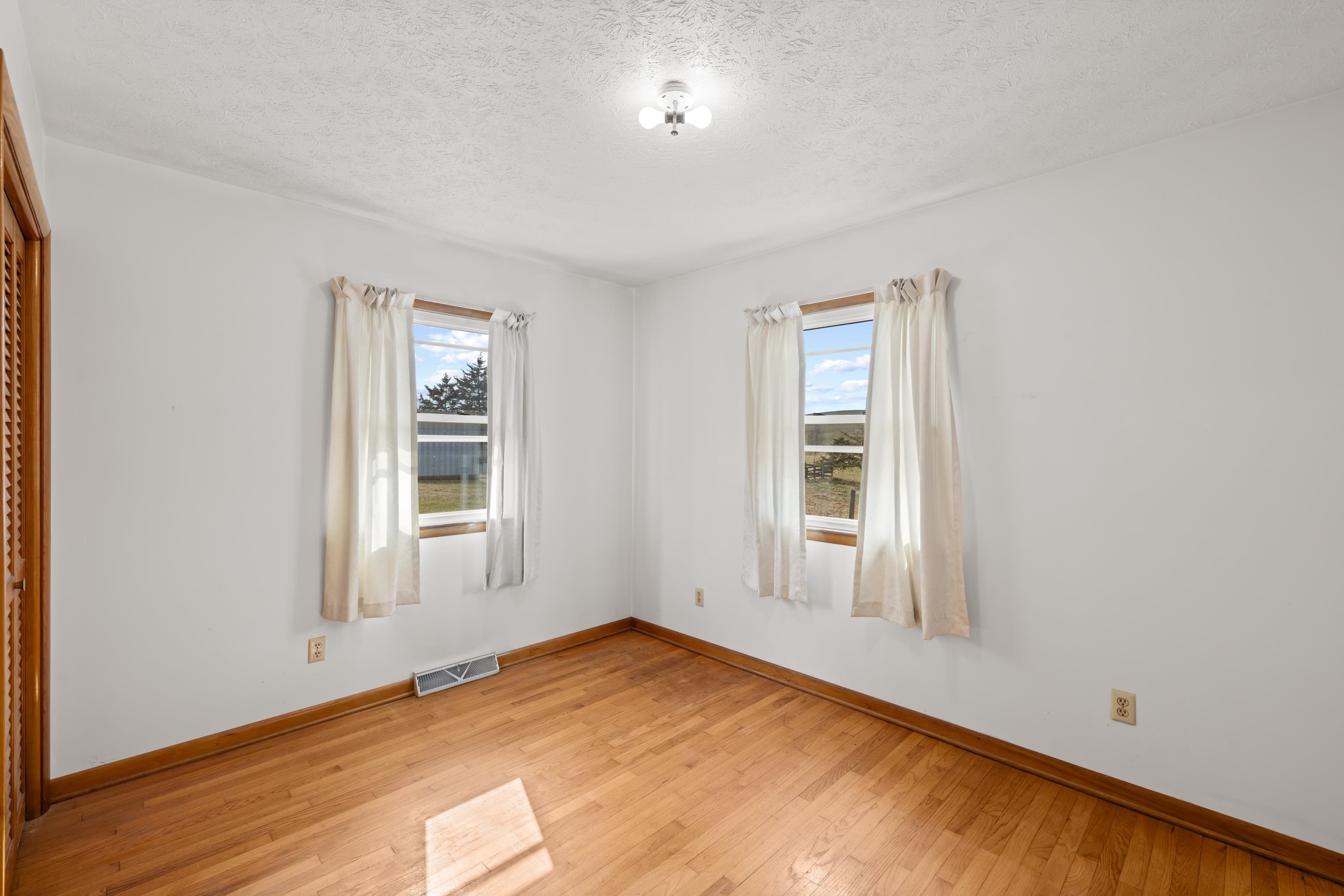 3493 Zion Church Road Broadway, VA 22815 - Photo 19 of 74 an empty room with wooden floor and windows
