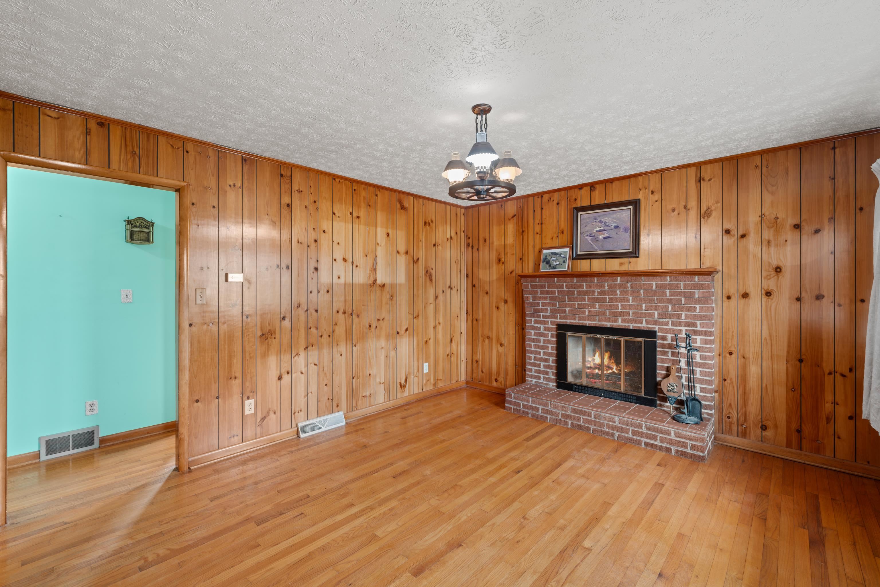 3493 Zion Church Road Broadway, VA 22815 - Photo 9 of 74 a view of a livingroom with a fireplace wooden floor and chandelier