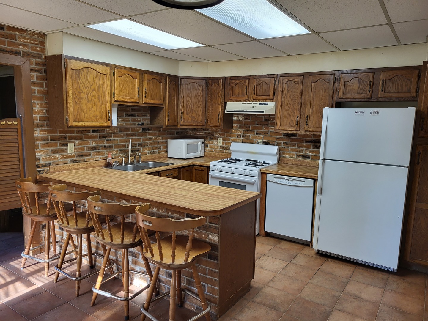 102 South 9th Street Rochelle, IL 61068 - Photo 4 of 13 a kitchen with stainless steel appliances a refrigerator a stove a sink a stove a dining table and chairs