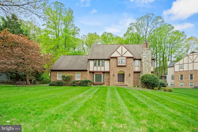 a view of a house with a big yard plants and large trees