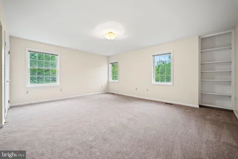 an empty room with windows and closet