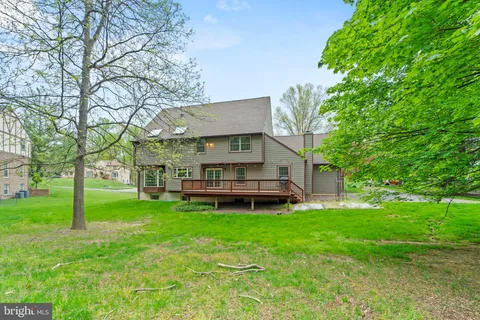 a backyard of a house with table and chairs and a large tree