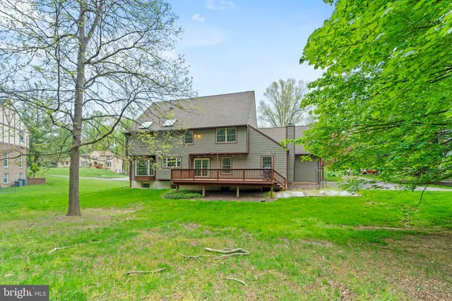 a backyard of a house with table and chairs and a large tree