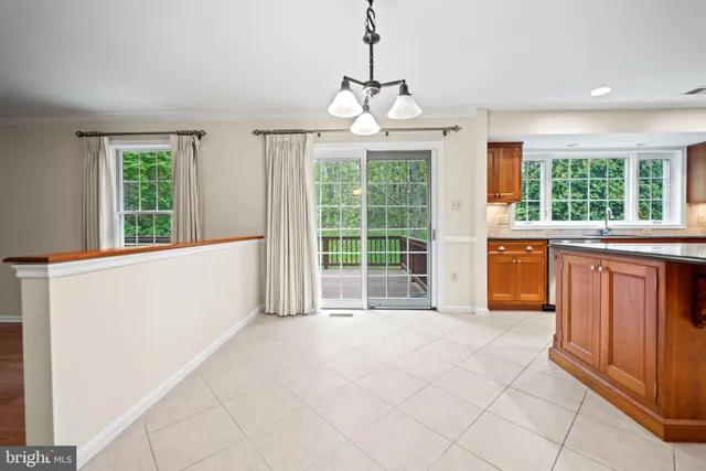 a view of an empty room with window cabinet and front door