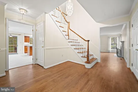 a view of a hallway with wooden floor and stairs