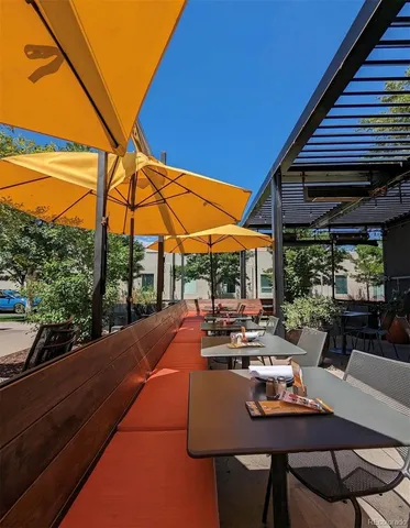 a view of patio with chairs and table under an umbrella