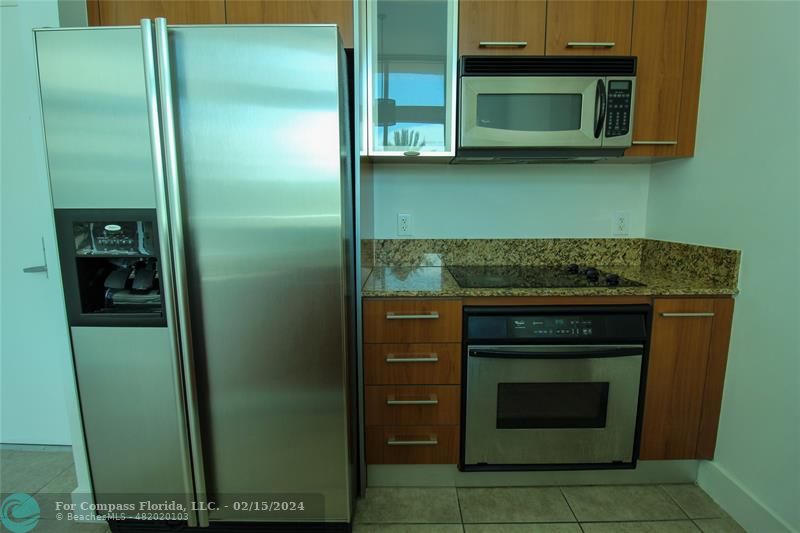 a kitchen with stainless steel appliances granite countertop cabinets and a microwave oven
