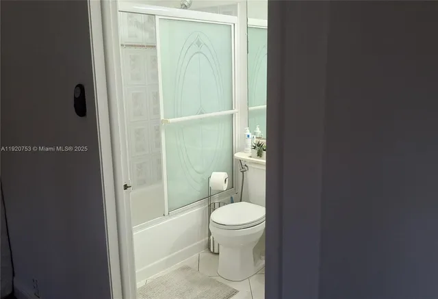 a bathroom with a granite countertop toilet and a shower