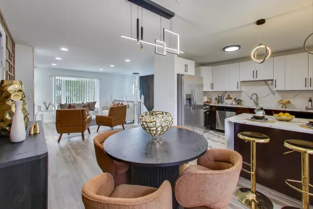 a kitchen with sink refrigerator dining table and chairs