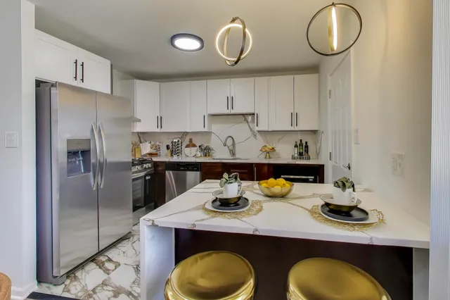 a kitchen with stainless steel appliances granite countertop a refrigerator and a stove