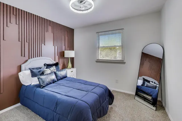 a view of a bedroom with a bed and window